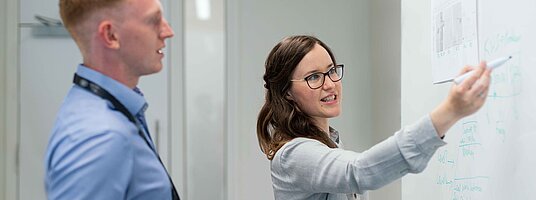 Zwei Geschäftsleute am White Board